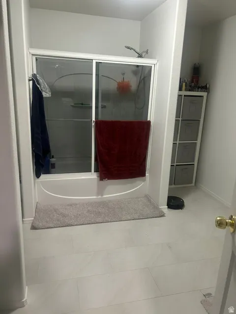 Full bathtub with a glass sliding shower door
