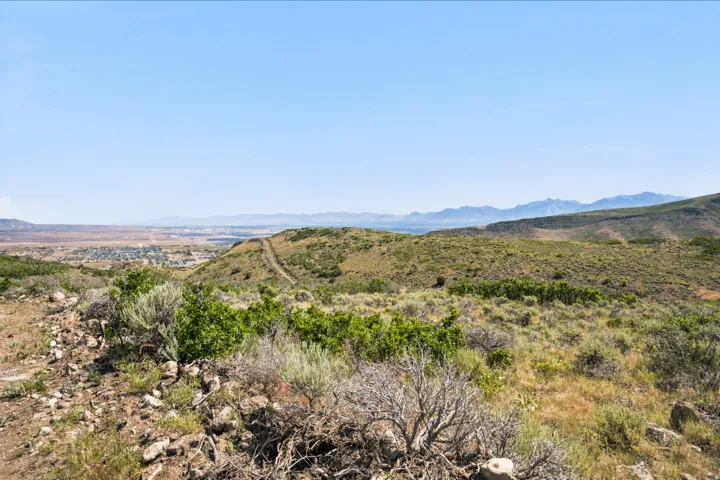 Expansive natural landscape featuring rolling hills and distant mountains