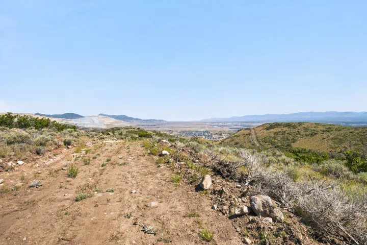 Expansive natural landscape featuring rolling hills and distant mountain ranges