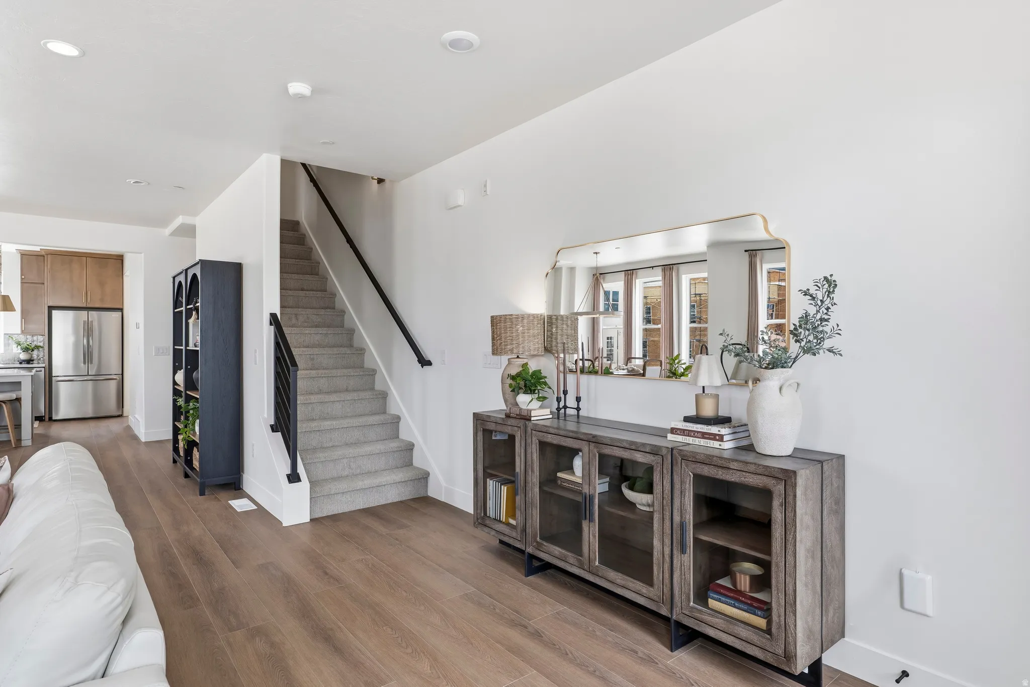Wide plank wood-finish flooring extending into the kitchen area