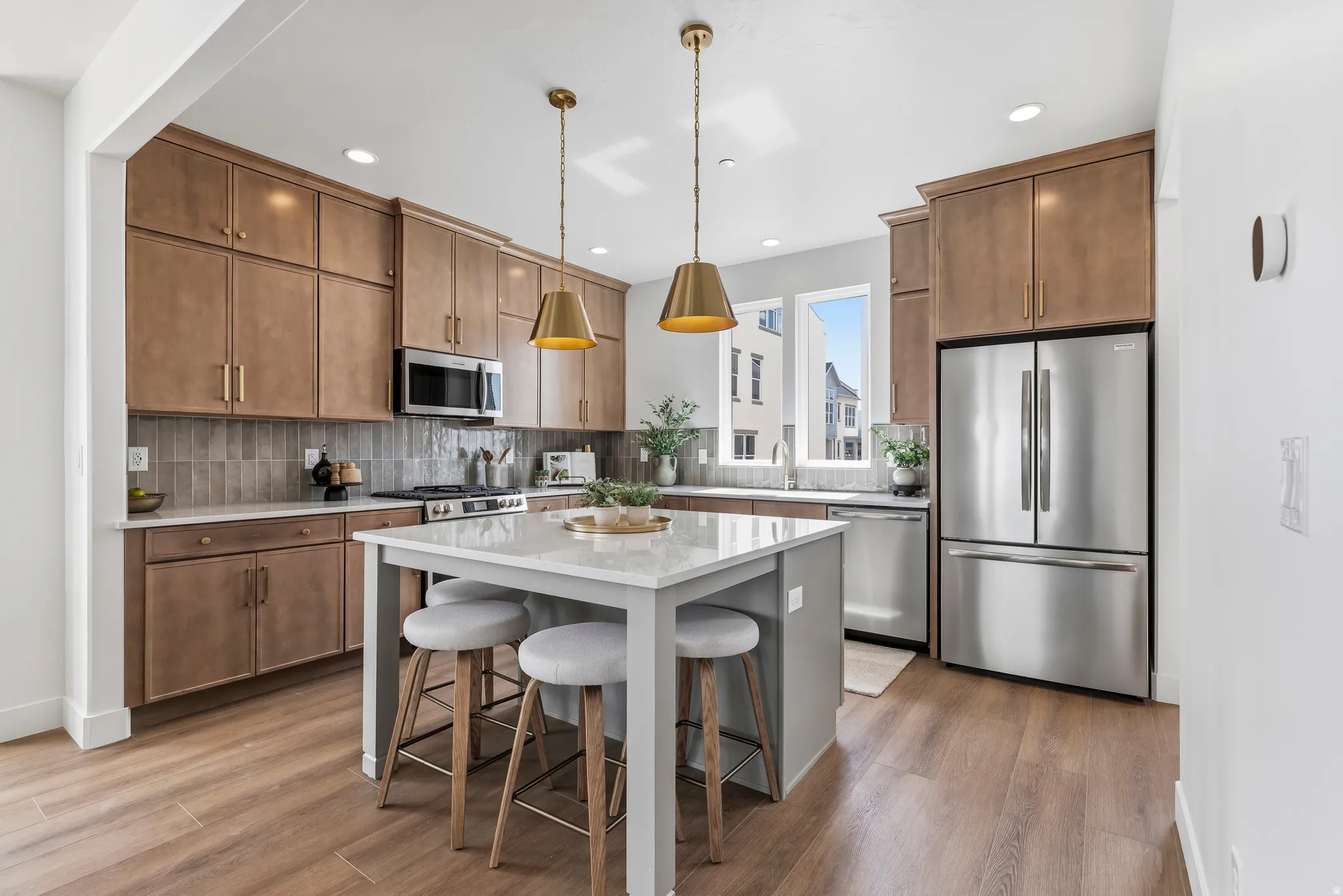 Open-concept kitchen featuring wood-finish flooring and a central island with a white countertop