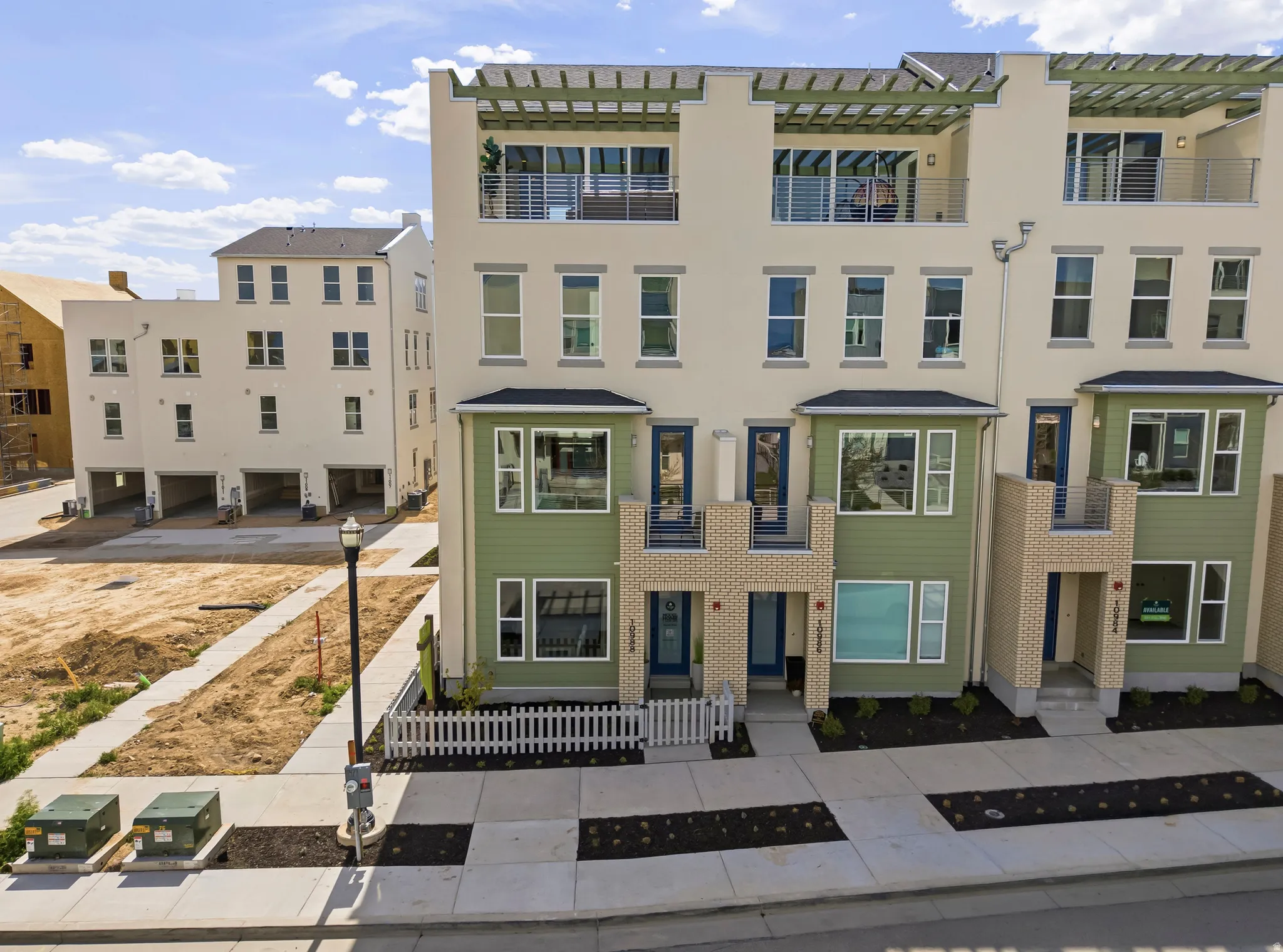 Contemporary townhome architecture featuring a multi-level facade, private balconies with metal railings, and a ground-level entrance