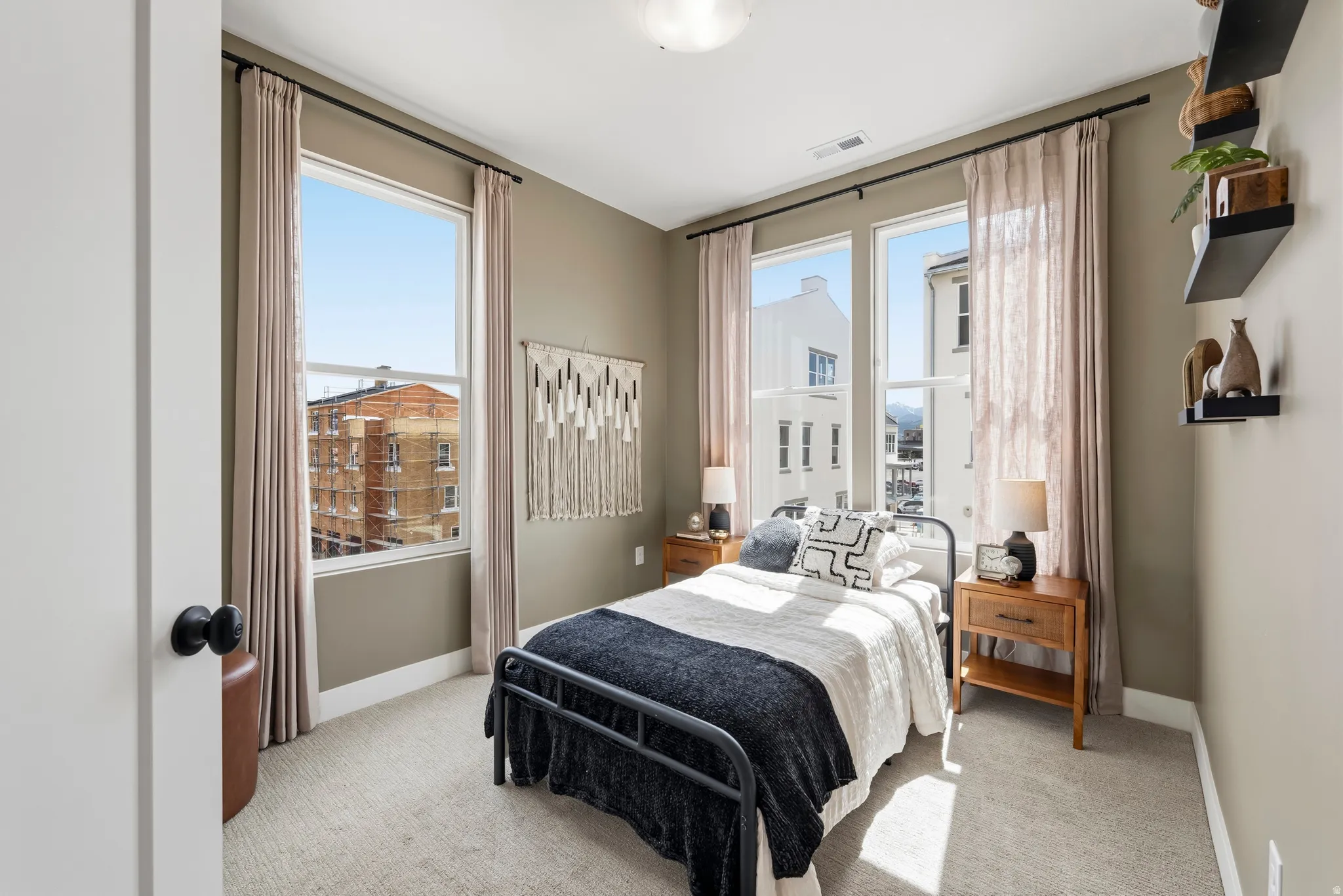 Bedroom featuring tall windows, light-toned carpeting, and neutral wall tones