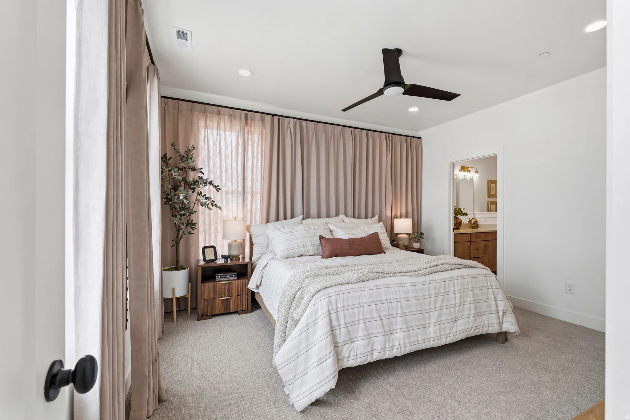 Carpeted bedroom featuring a large window with full-height drapes, recessed lighting, and a contemporary ceiling fan