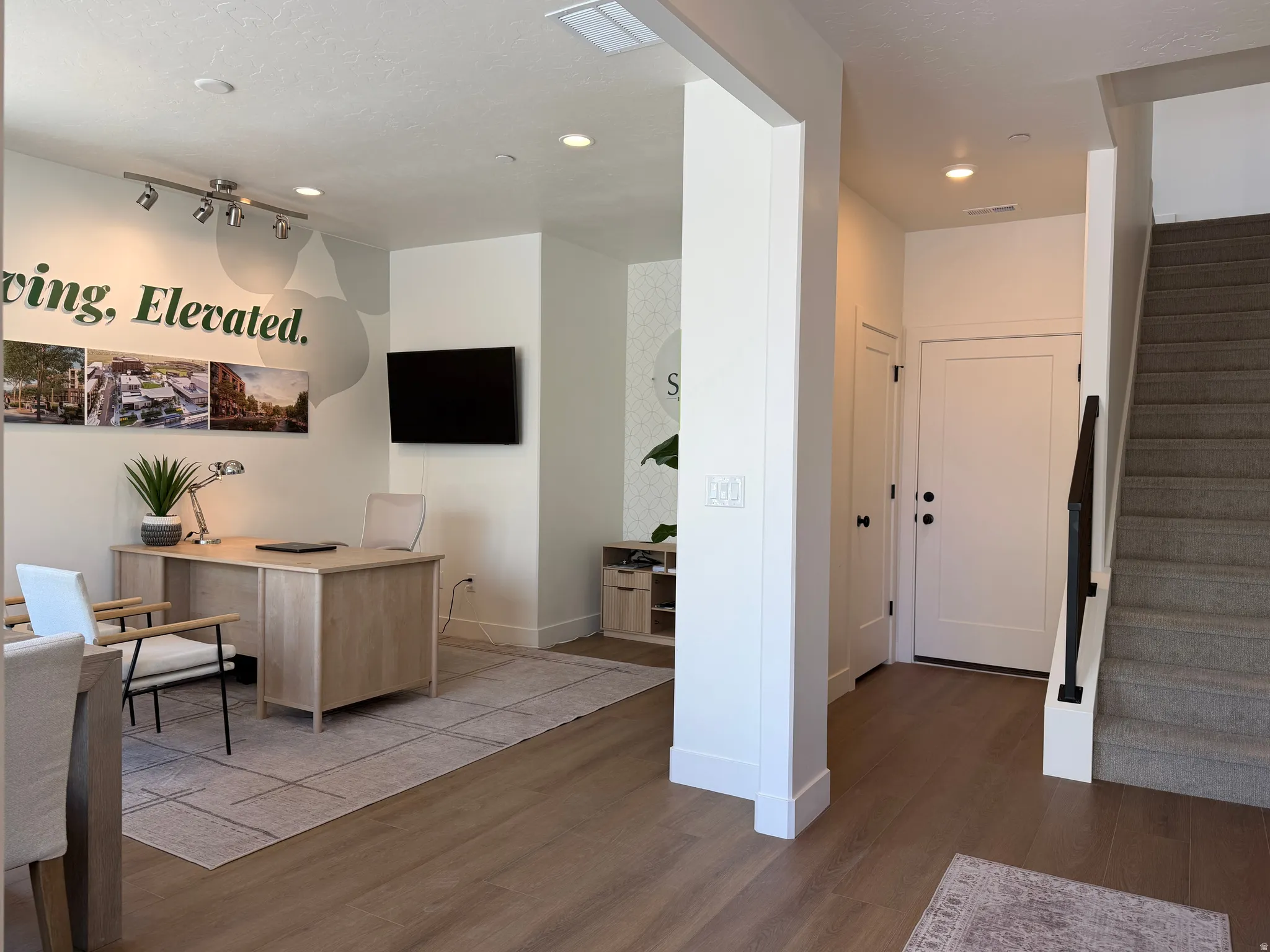 Open floor plan featuring wood-finish flooring, recessed lighting, and a neutral color palette