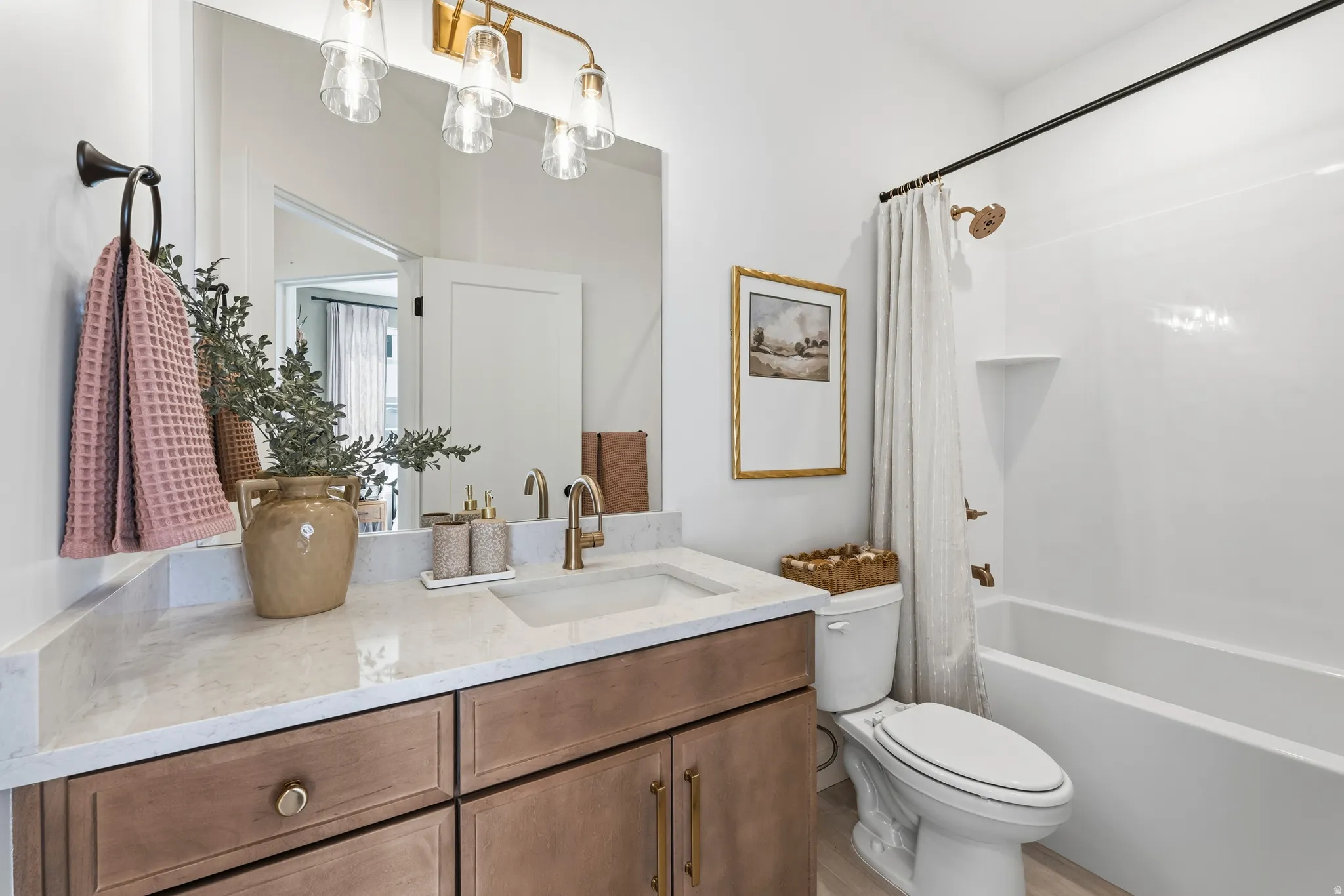 Bathroom vanity featuring a light-toned countertop, integrated sink, and wood-finish cabinetry