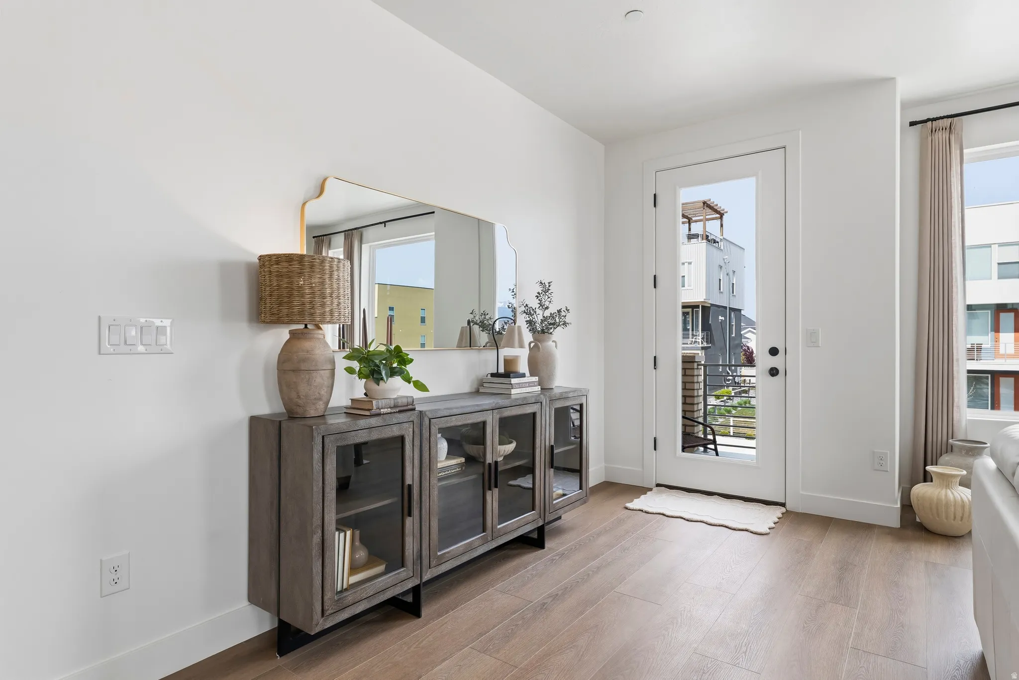 Wood-finish flooring and white baseboards complement the bright white walls