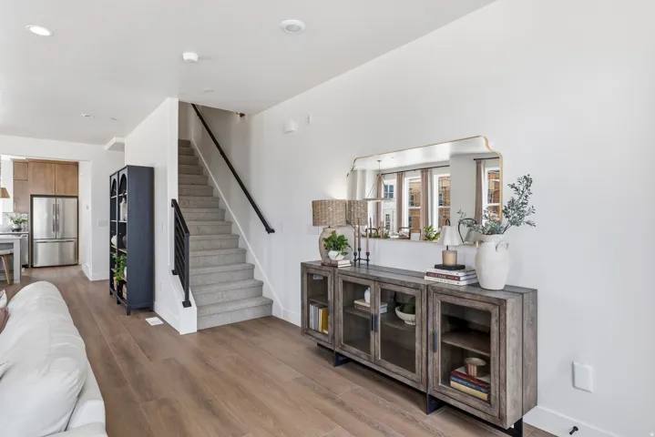 Wide plank wood-finish flooring extending into the kitchen area