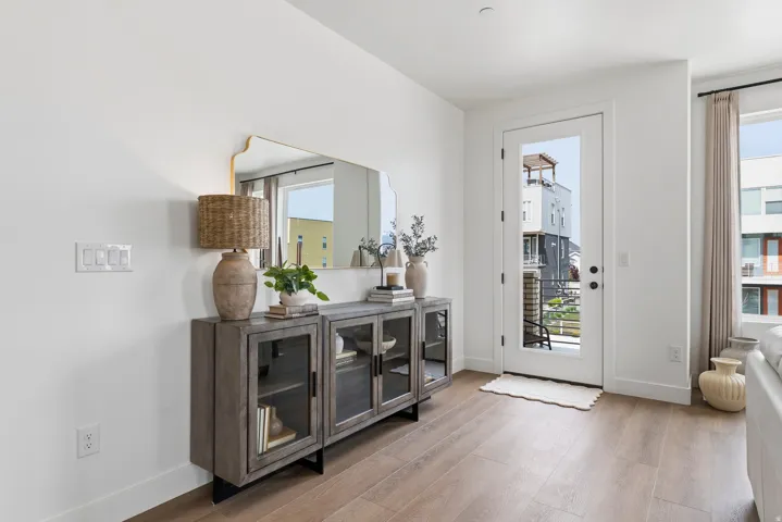 Wood-finish flooring and white baseboards complement the bright white walls