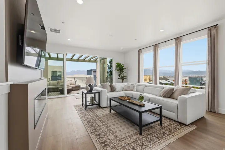 Living area featuring wood-finish flooring, recessed lighting, and a linear electric fireplace