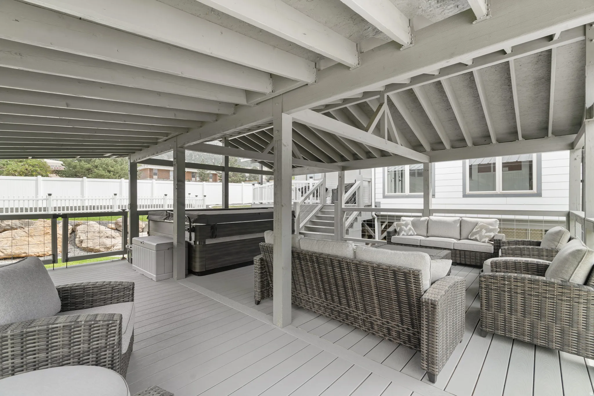 Custom-built covered gazebo deck with quality 6x6 construction, exposed beam ceiling, composite decking, and glass railings. Spacious design offers the perfect setting for outdoor gatherings and hot tub enjoyment