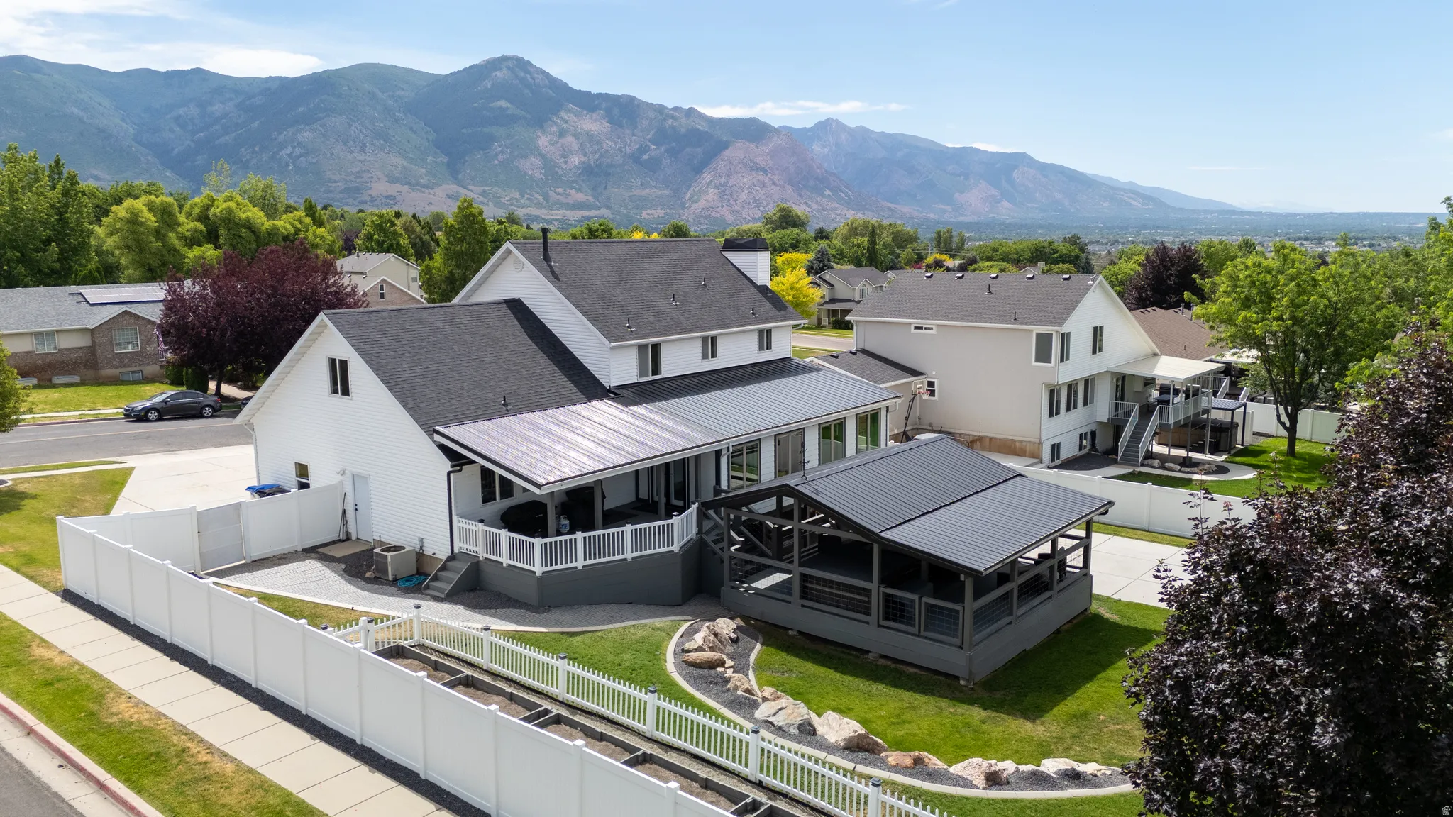 Aerial view of two-story residence featuring a white exterior and dark shingle roof
