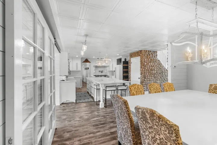 Open-concept living space featuring top of line LPV flooring, a white coffered ceiling, and a stone-clad stairwell