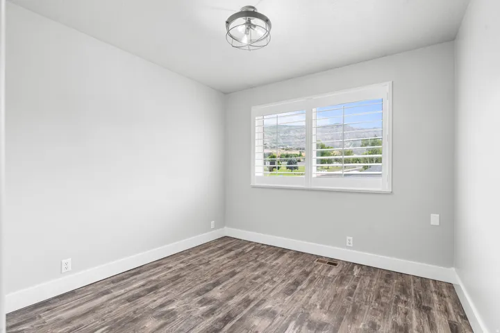 Bedroom featuring LPV flooring, white baseboards, and a contemporary semi-flush mount light fixture