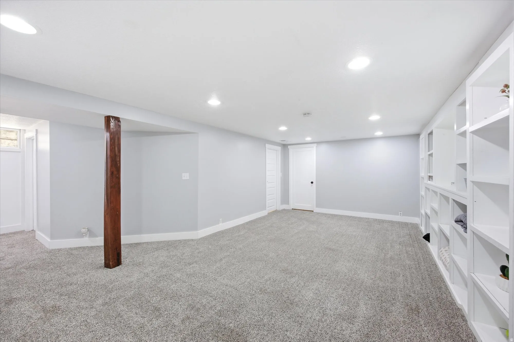Finished lower level featuring recessed lighting, a neutral gray color palette, and built-in shelving