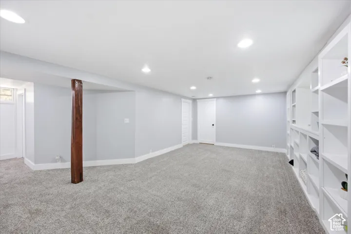 Finished lower level featuring recessed lighting, a neutral gray color palette, and built-in shelving