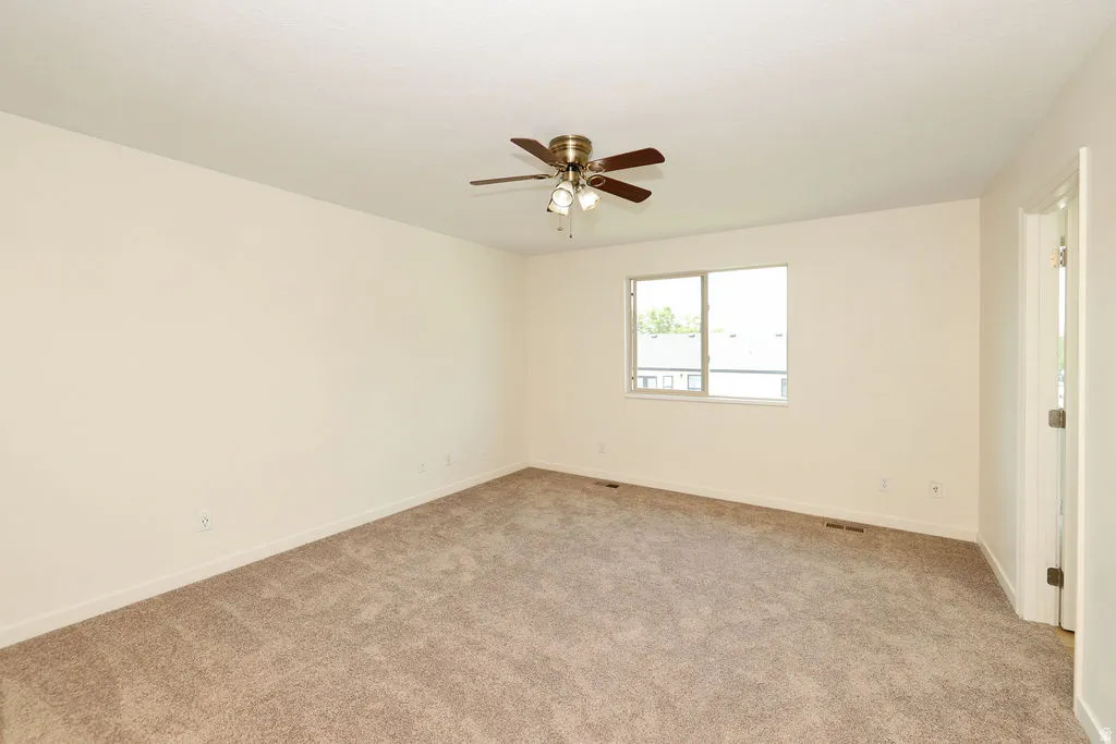 Spacious room featuring neutral carpeting and light-toned walls