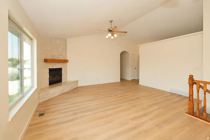 Spacious living area featuring light wood-finish flooring and vaulted ceilings