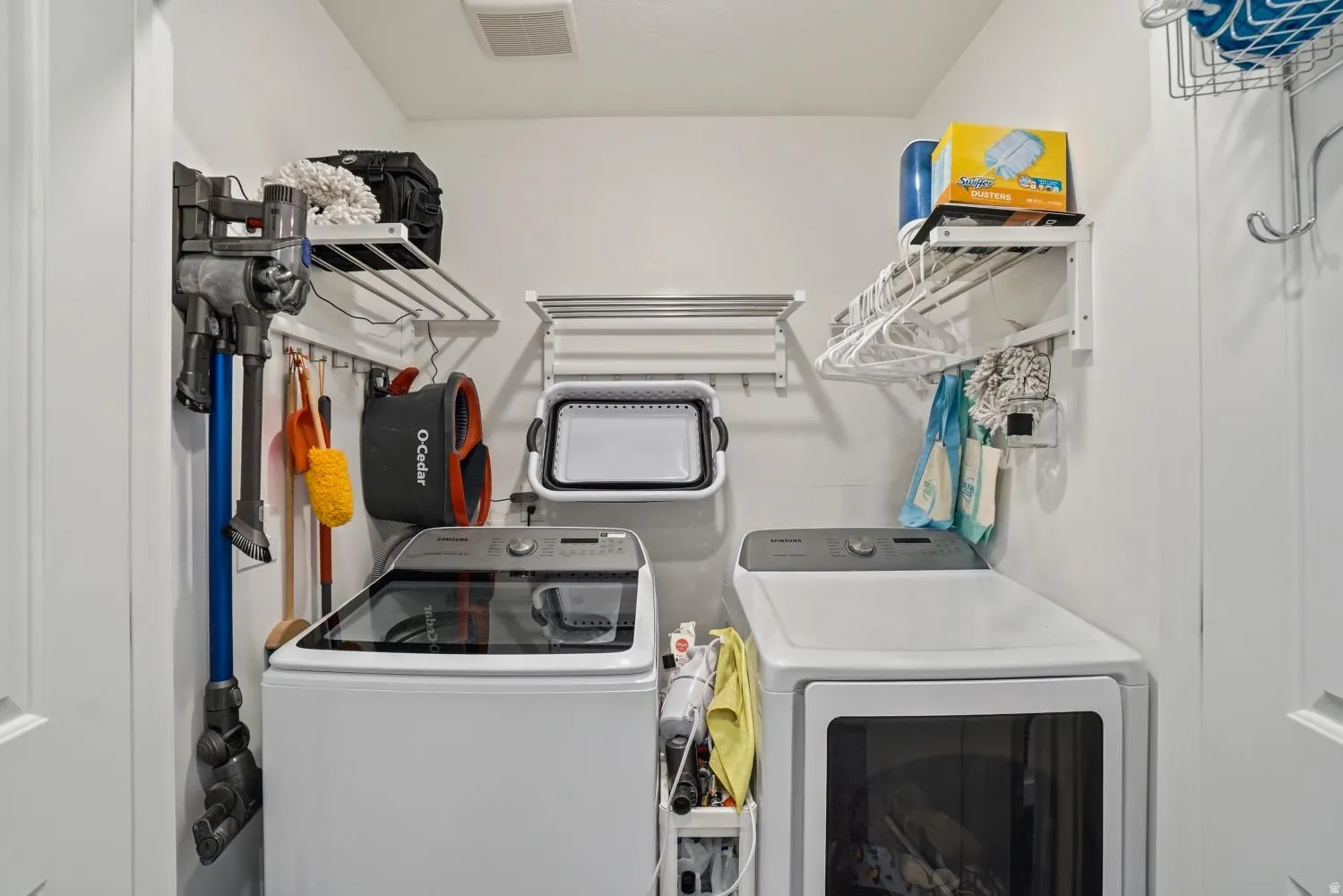 Dedicated laundry space featuring a white top-load washing machine and front-load dryer