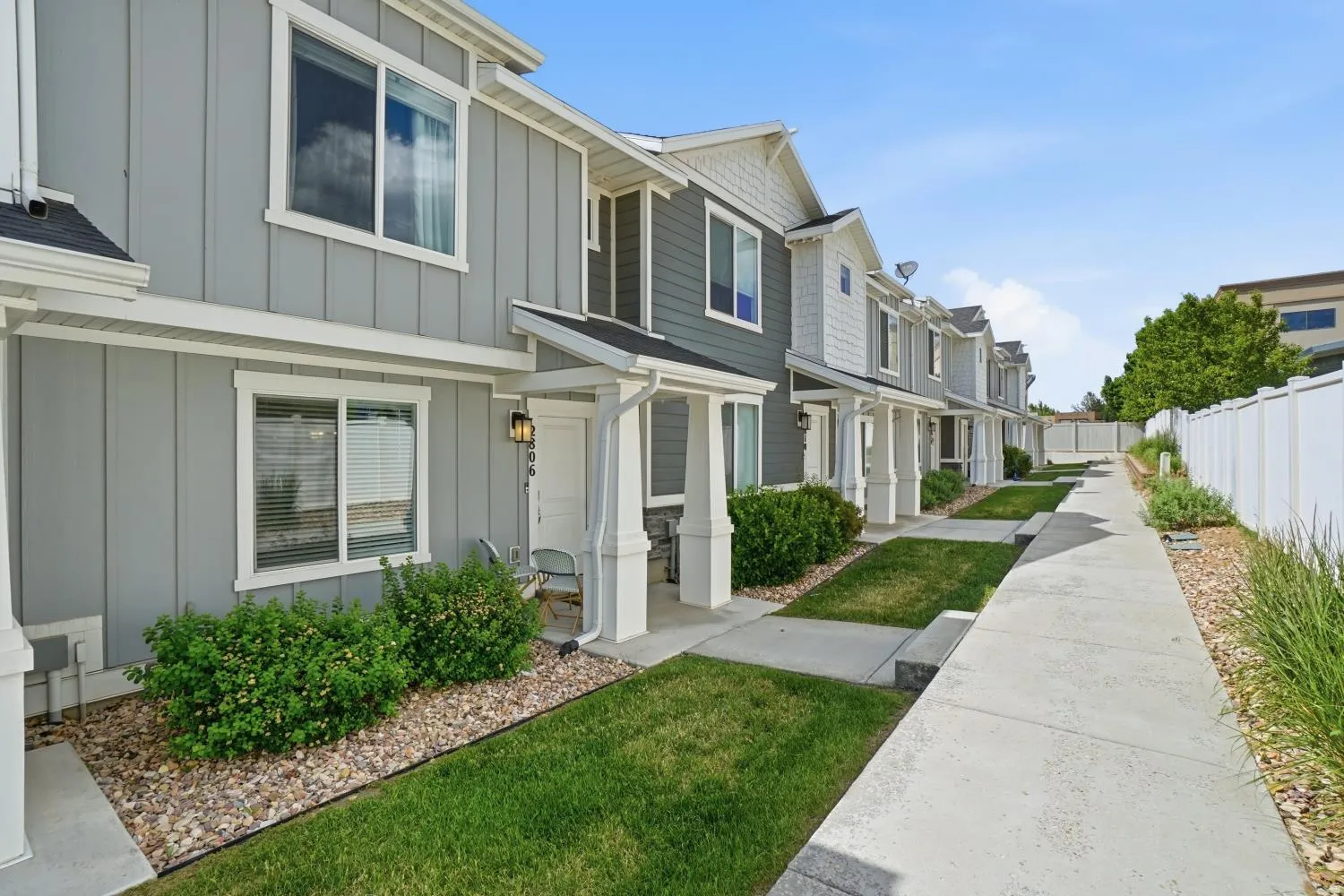 Modern townhome exterior featuring light gray board-and-batten siding and white trim