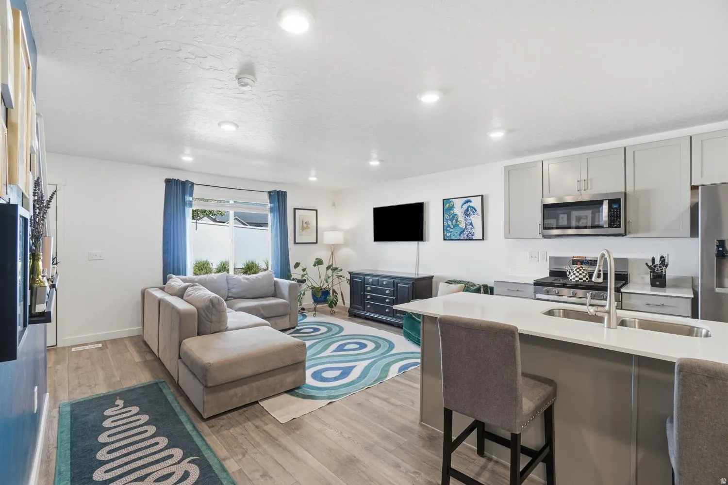 Open-concept living space featuring wood-finish flooring, recessed lighting, and a sliding glass door