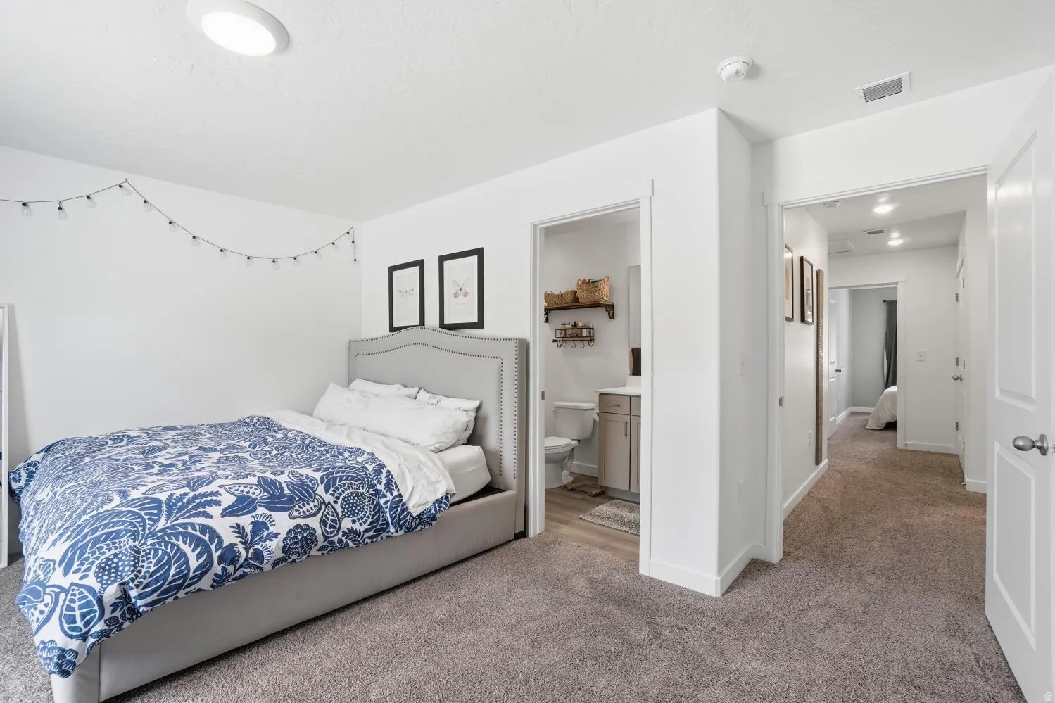 Carpeted bedroom featuring white walls and a flush-mounted ceiling light