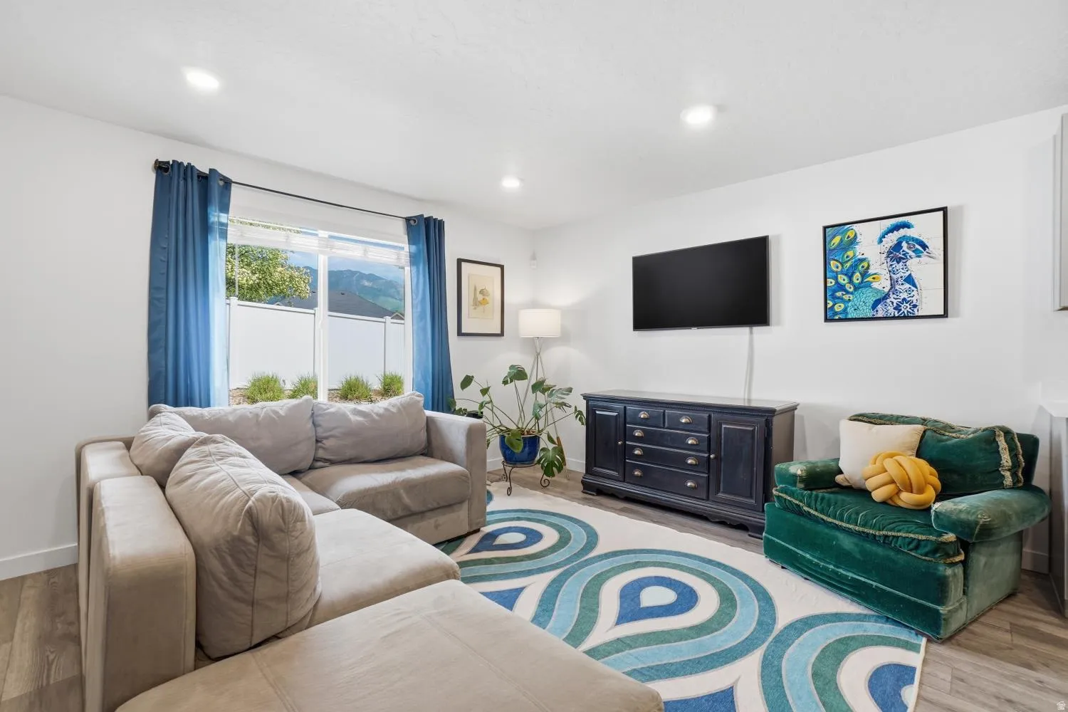 Bright living area featuring recessed lighting, a large window with mountain scenery, and durable wood-finish flooring