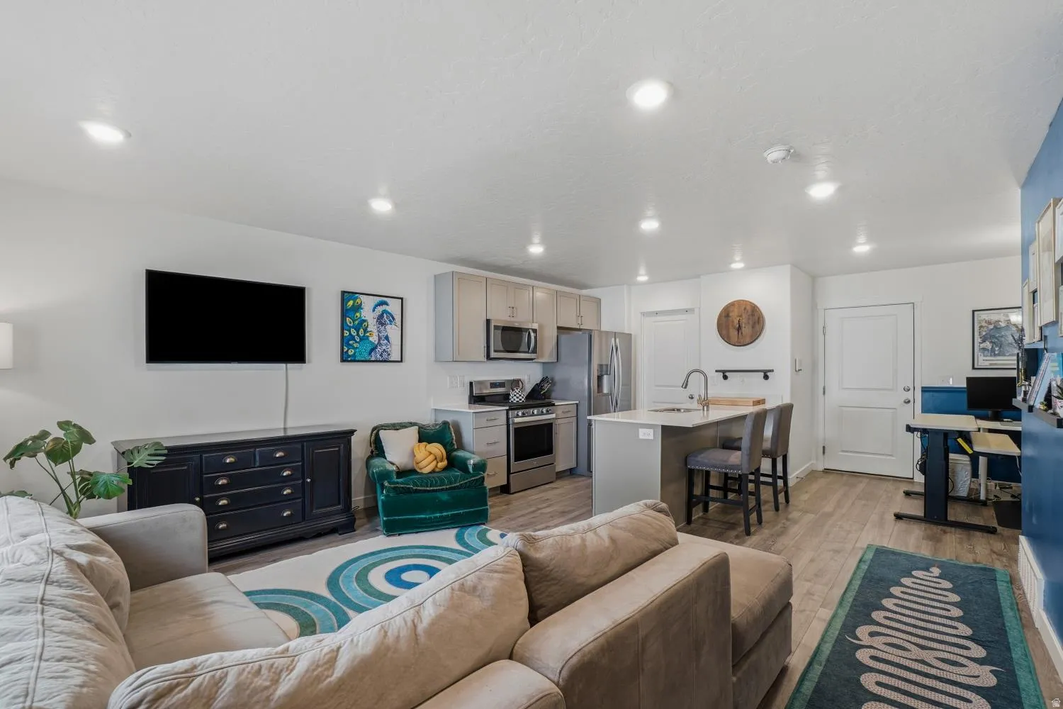 Open-concept living space featuring wood-finish flooring, recessed lighting, and a neutral color palette