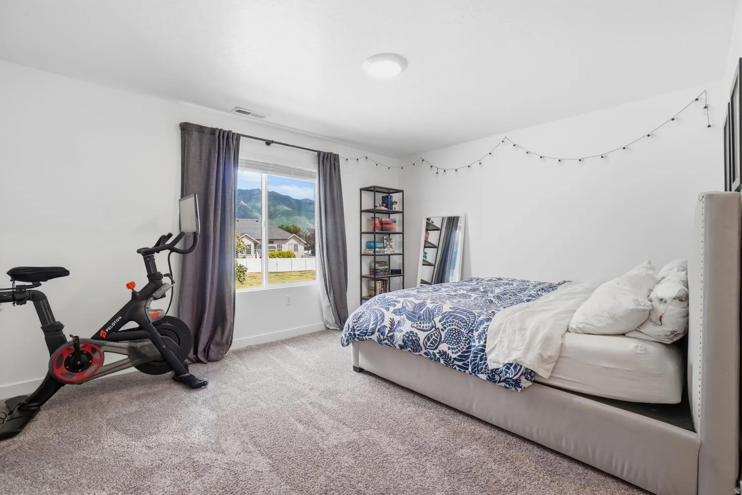 Carpeted room with a large window and mountain scenery