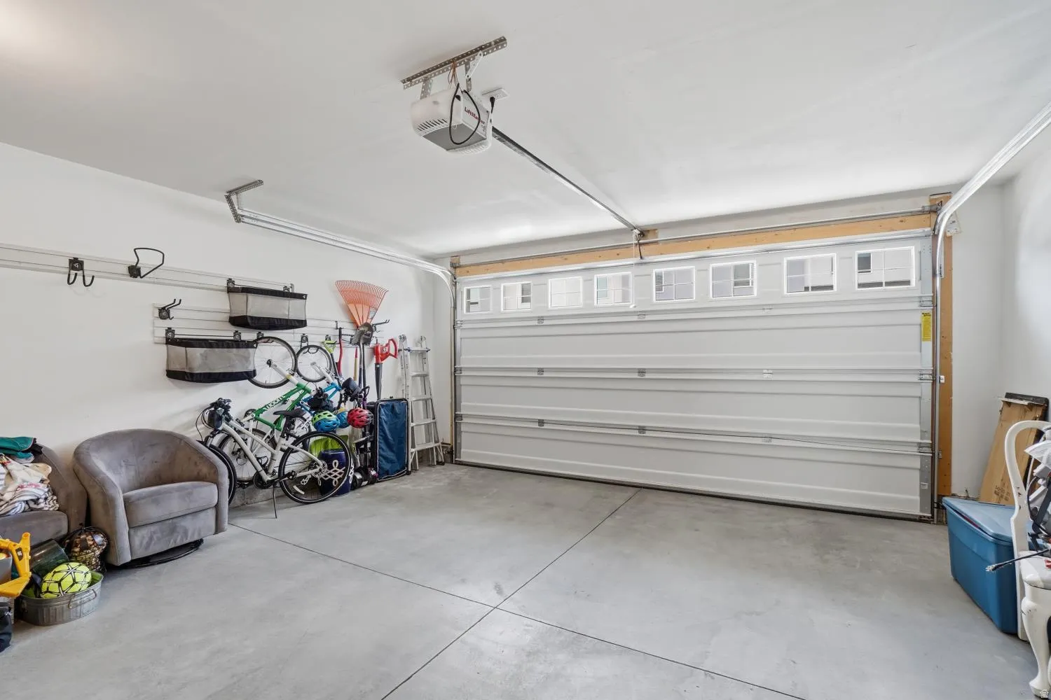 Spacious garage featuring a concrete floor, white walls, and an overhead garage door opener