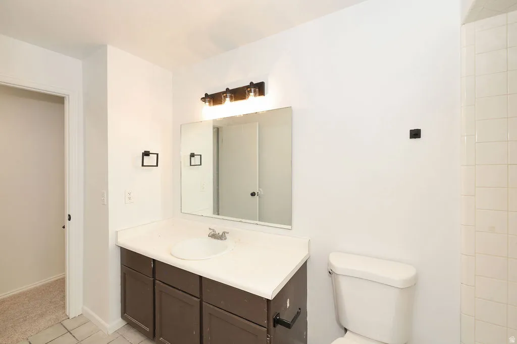 Bathroom vanity with a single basin sink, laminate countertop, and dark wood-finish cabinetry