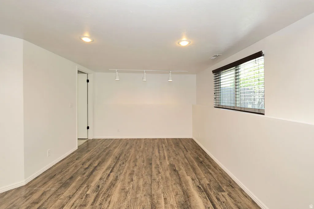 Spacious interior with wood-finish flooring, recessed lighting, and a track lighting fixture