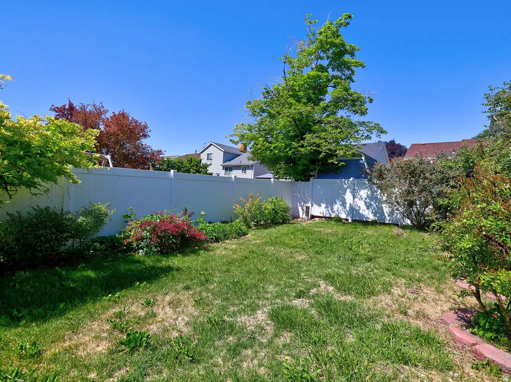 Expansive lawn area enclosed by a white privacy fence