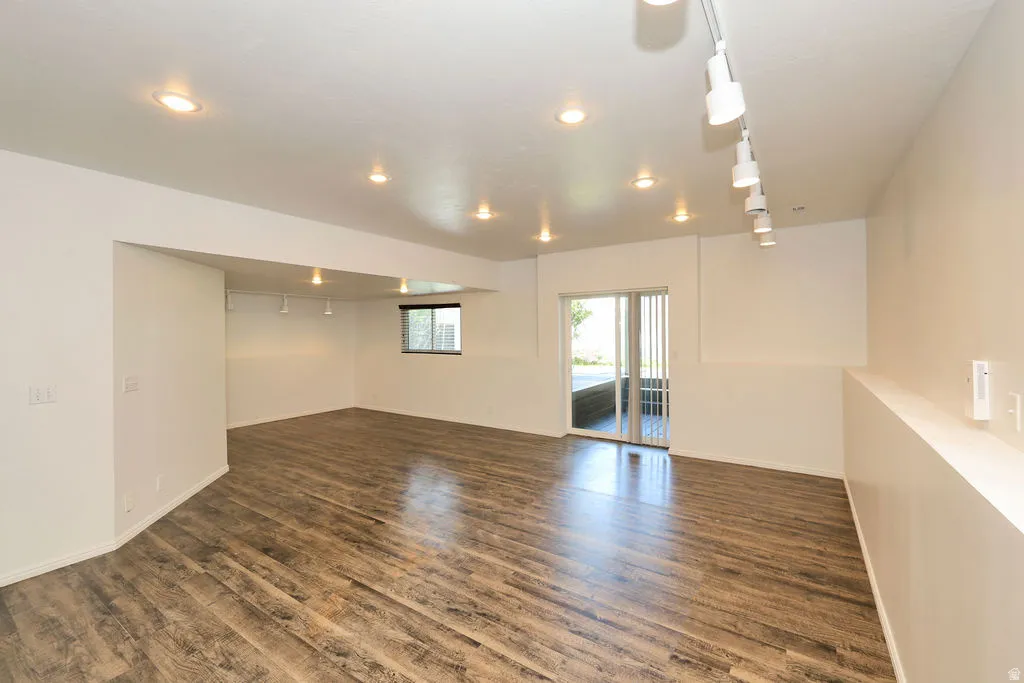Spacious room featuring wood-finish flooring, recessed lighting, and track lighting