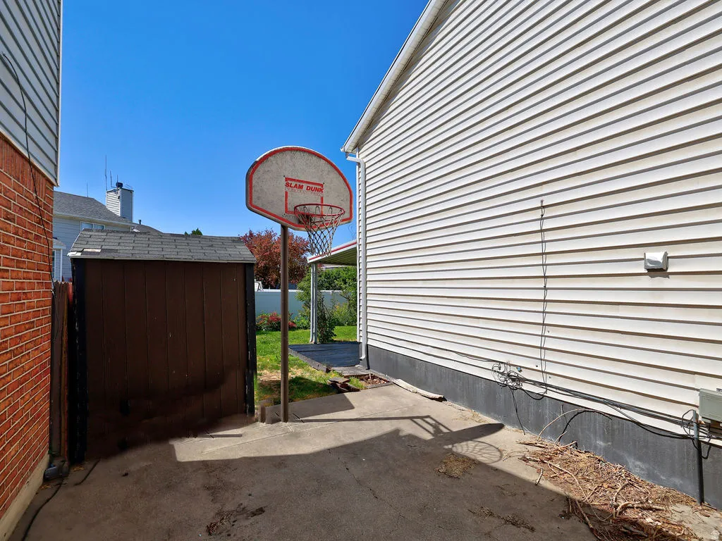 Concrete patio area featuring a basketball hoop