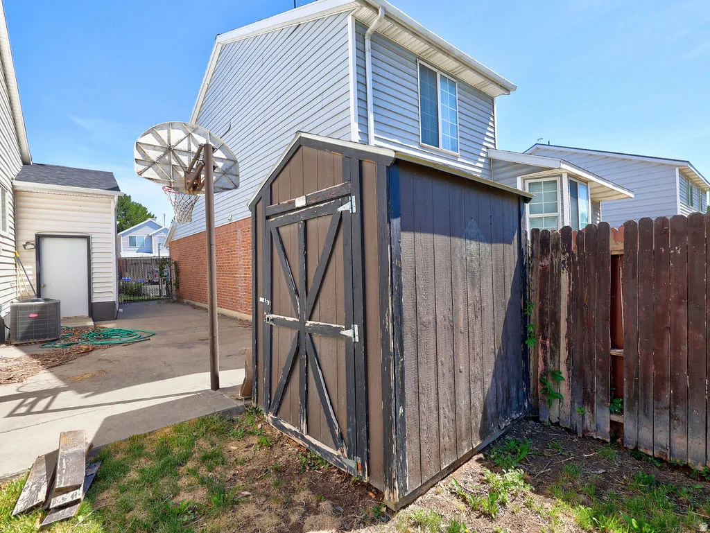 Backyard storage shed with wood paneling and a dark finish