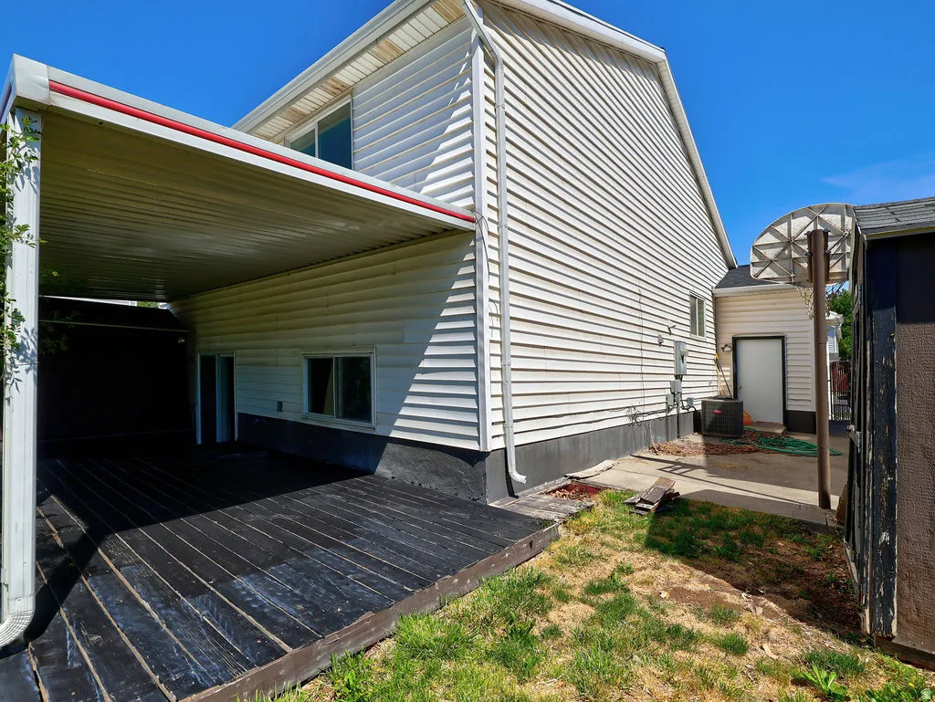 Covered outdoor deck with dark-stained wood flooring, featuring direct access to interior spaces