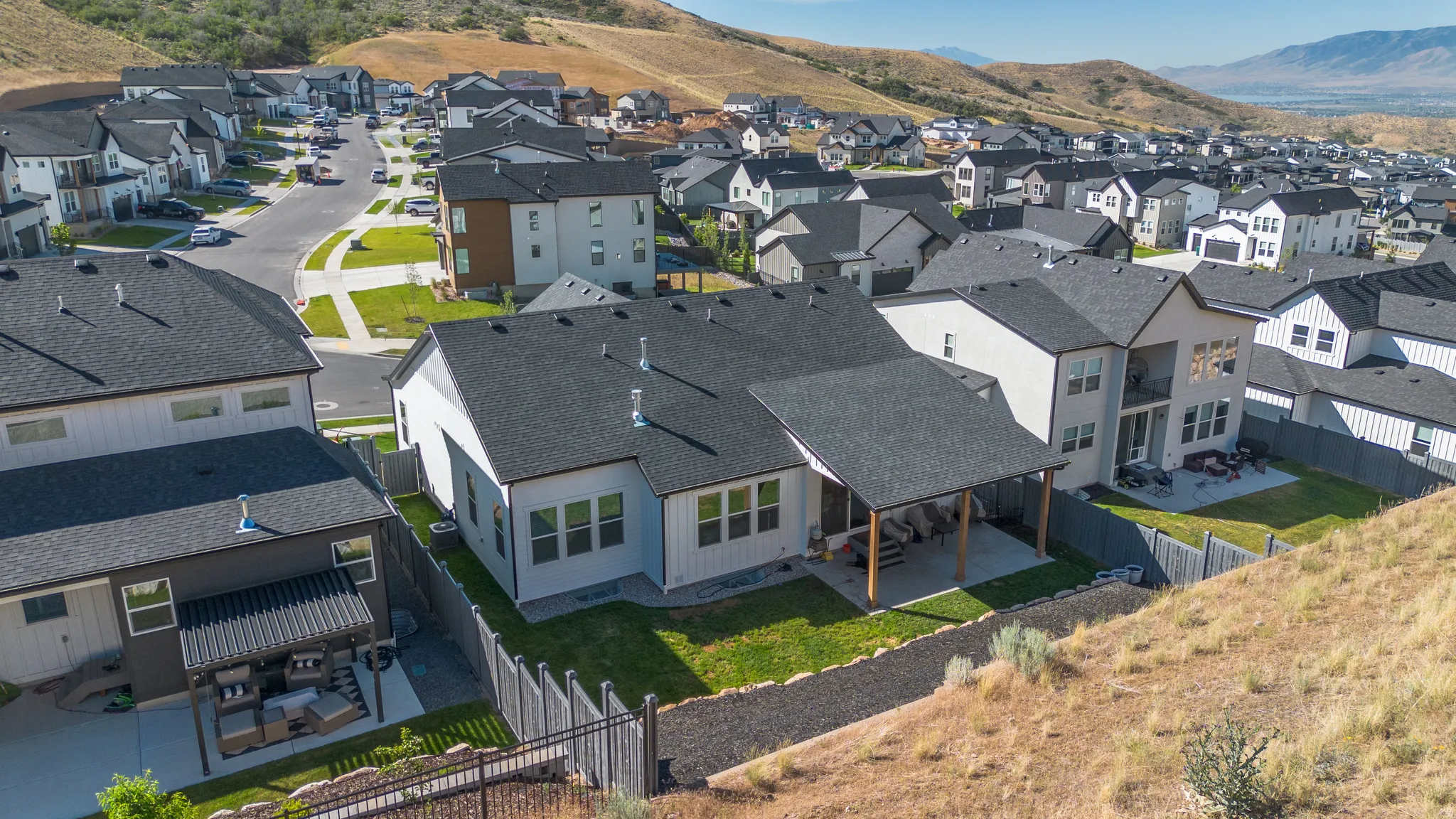 Contemporary home with a covered patio, fenced backyard, and a paved pathway