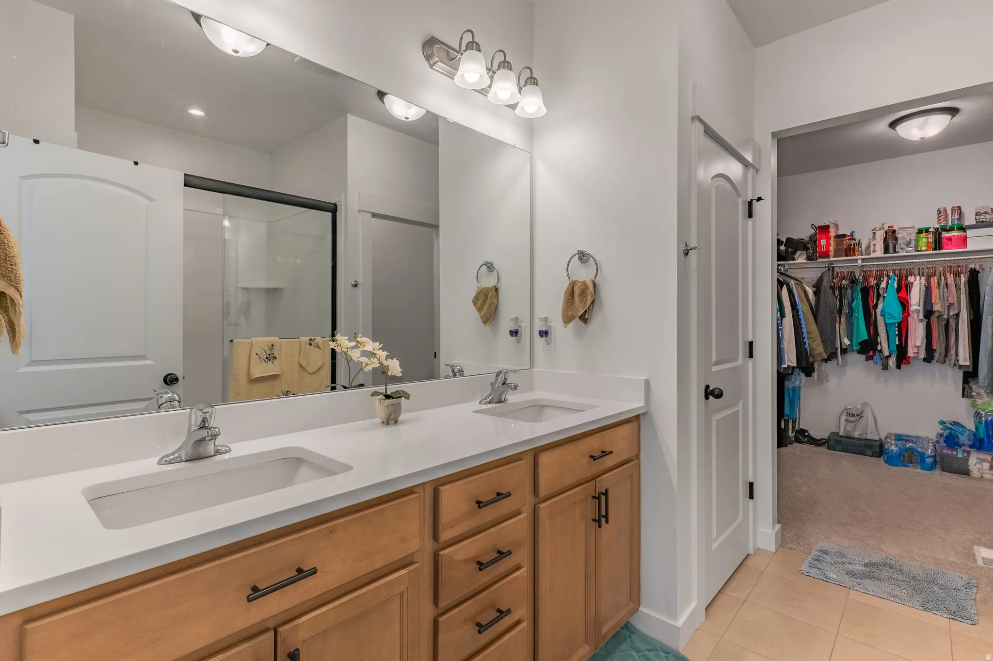 Double vanity with a light countertop and wood-finish cabinetry