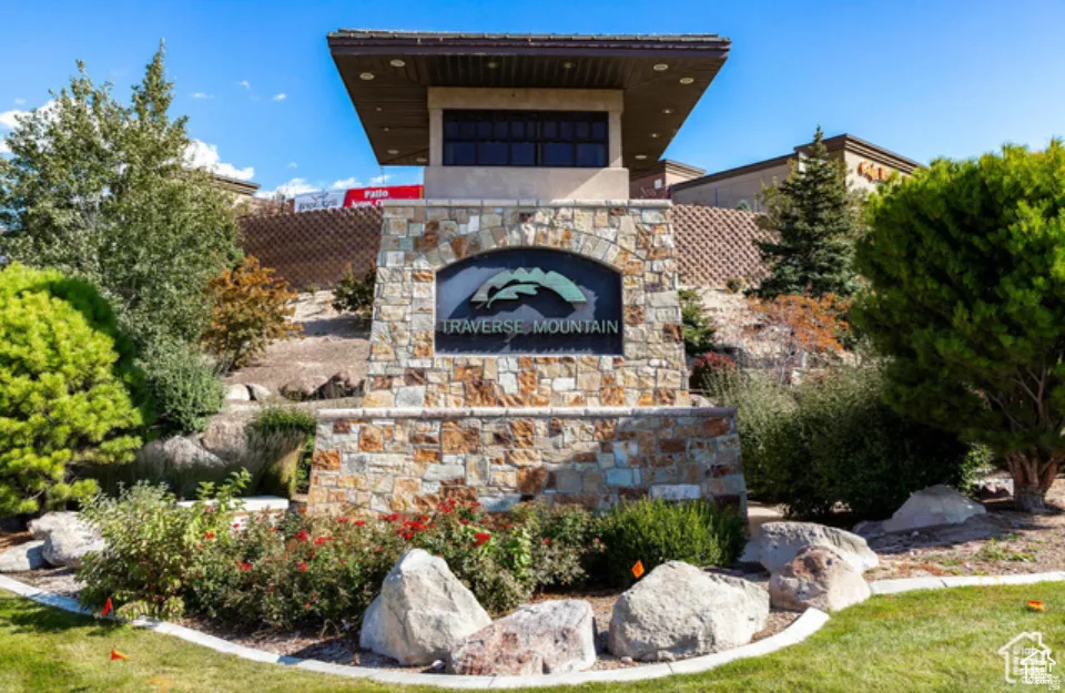 Community entrance featuring a natural stone sign with an arched top and integrated landscaping