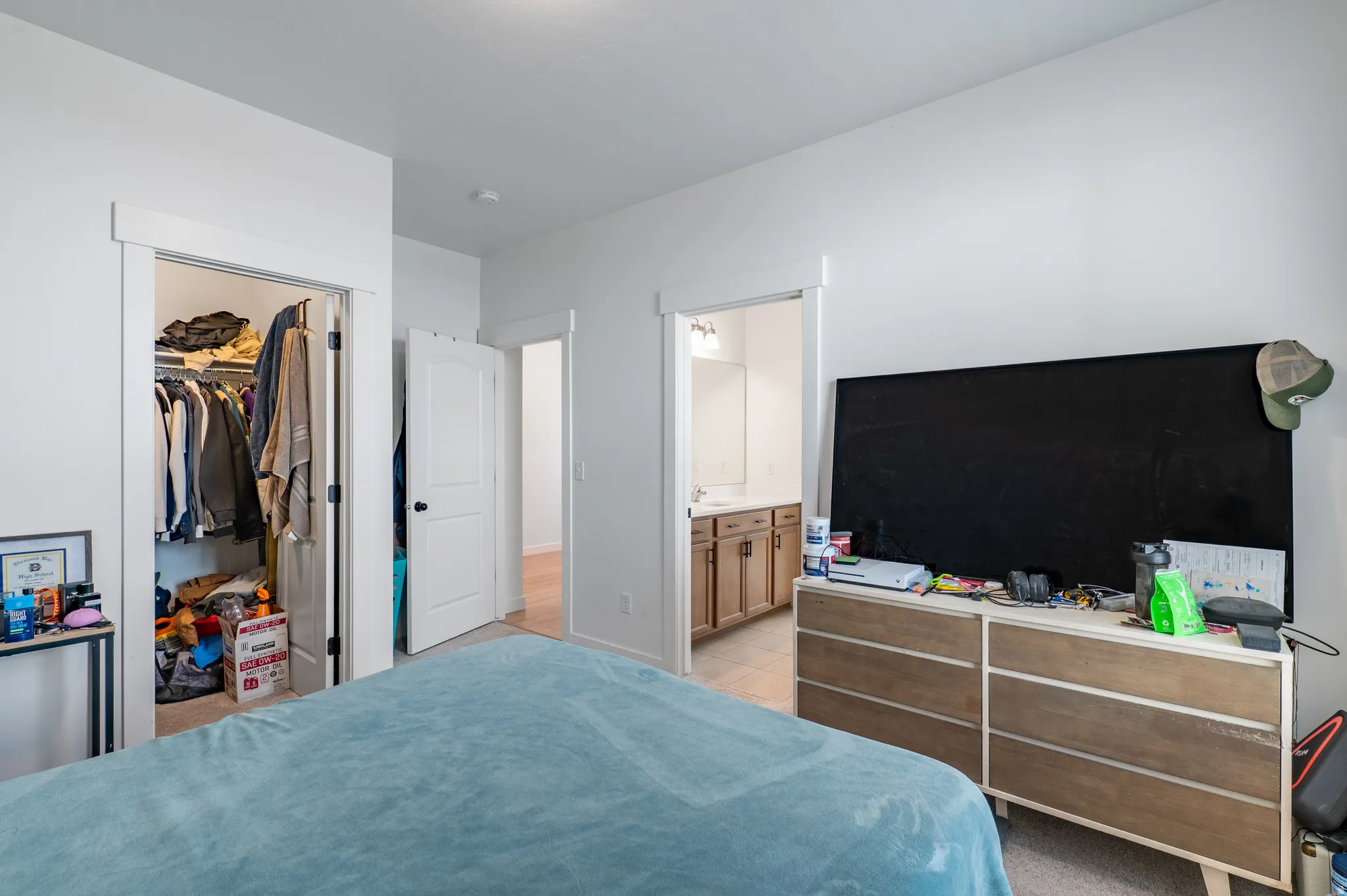 Bedroom featuring a closet with bi-fold door, white trim, and light-colored carpeting