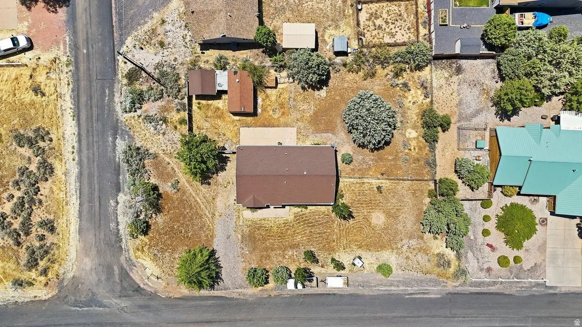 Single-story residence with a brown shingle roof, positioned on a corner lot