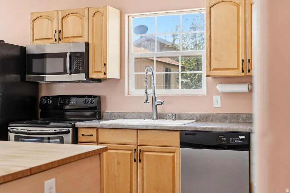 Kitchen featuring light wood cabinetry and grey flecked countertops