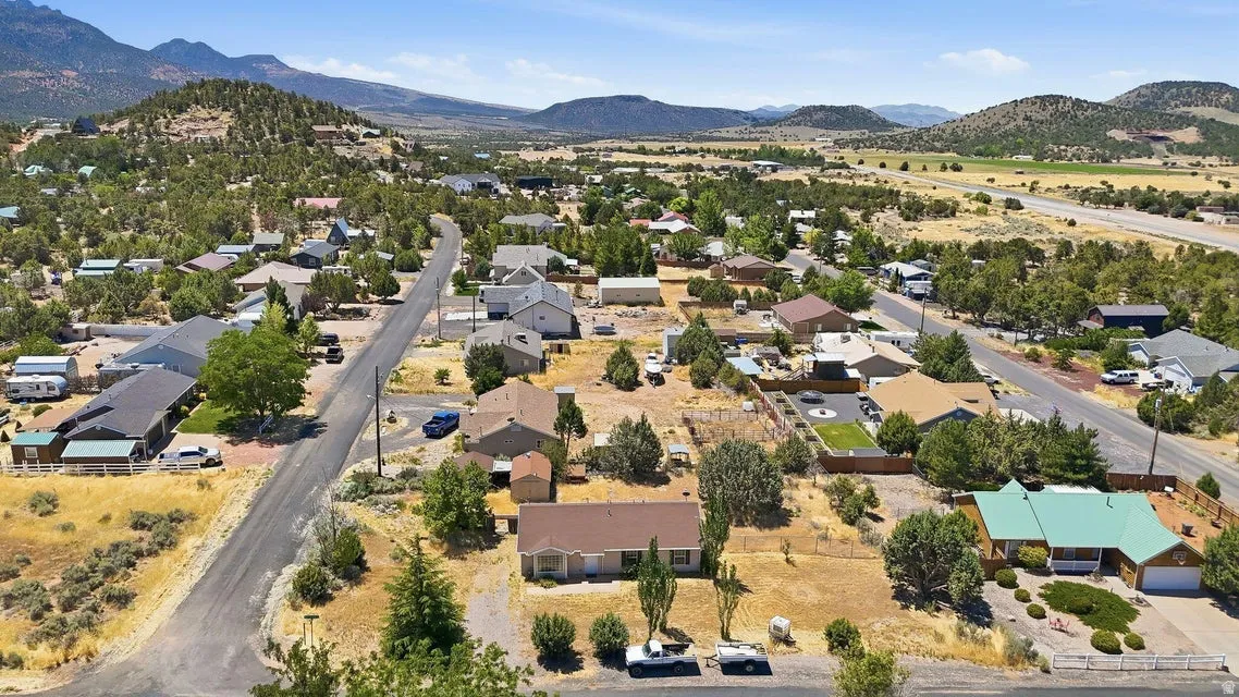Aerial perspective of a neighborhood featuring single-story homes, surrounded by natural desert landscaping and distant mountains
