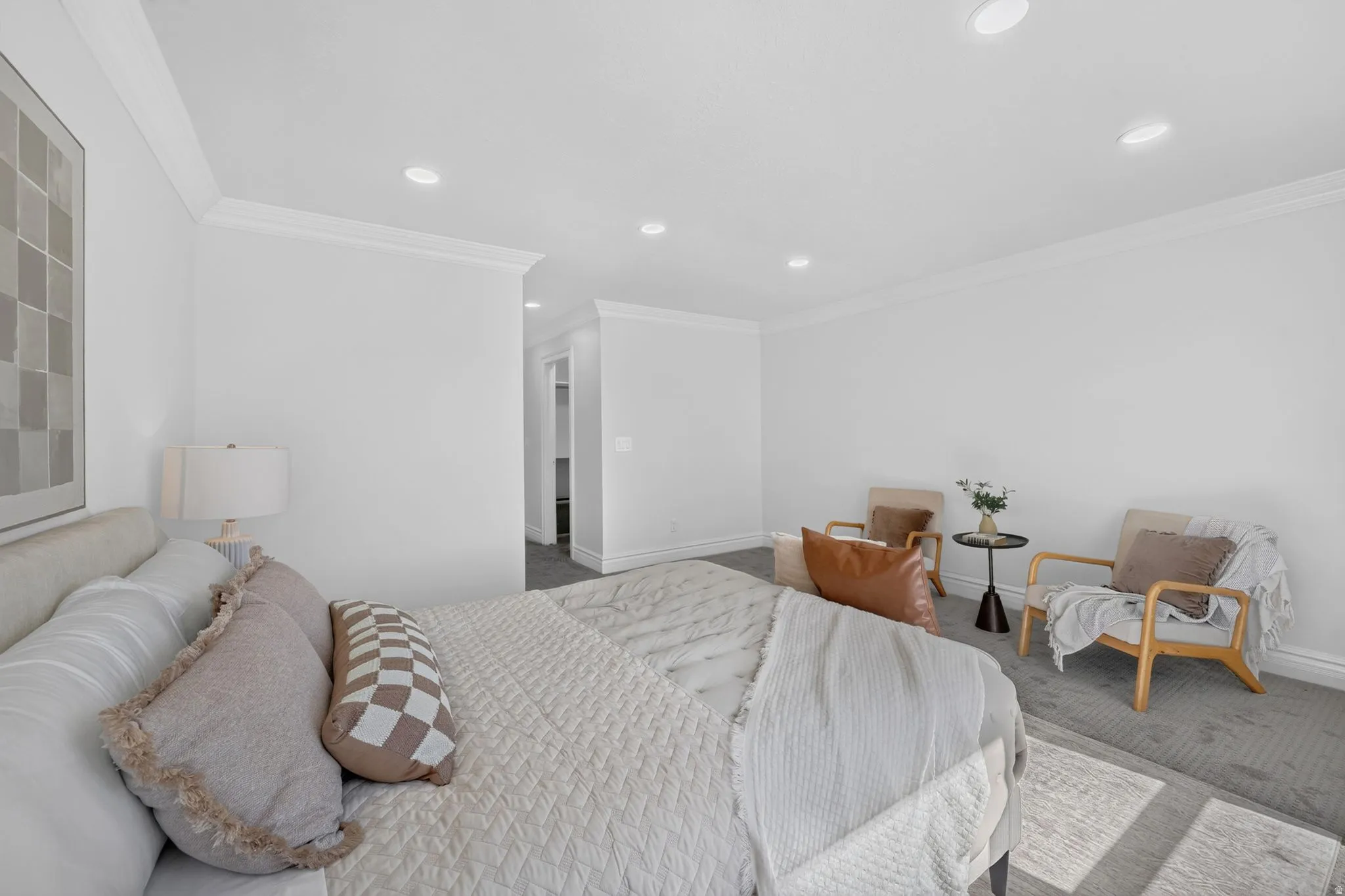 Spacious interior room featuring white walls, crown molding, recessed lighting, and grey carpeting