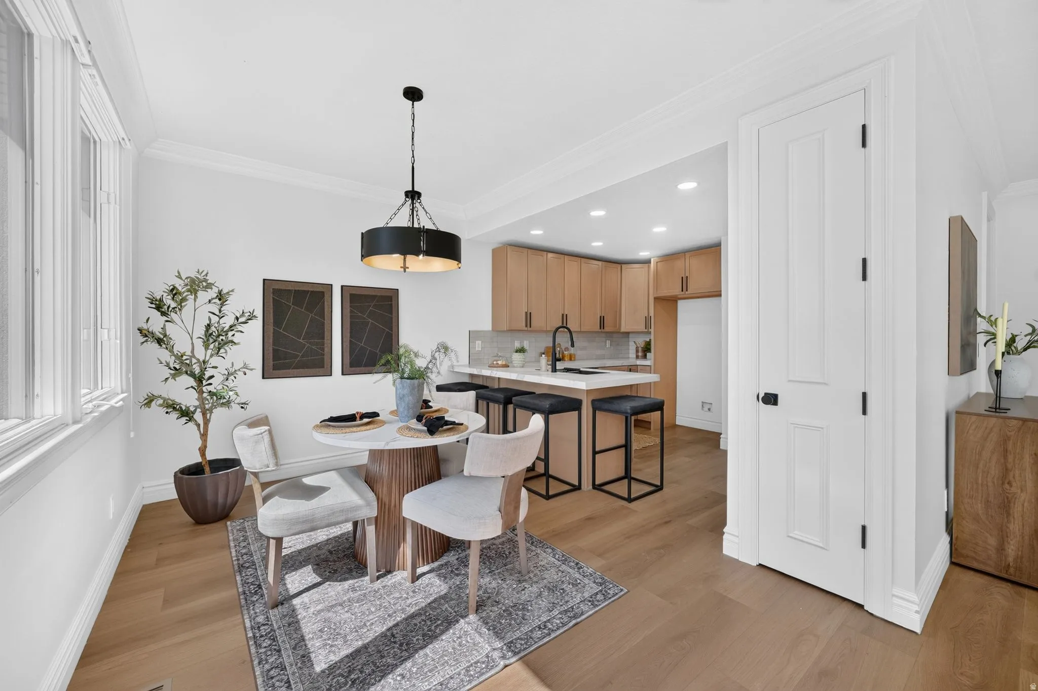 Open concept dining area featuring wood-finish flooring, a contemporary chandelier, and extensive windows