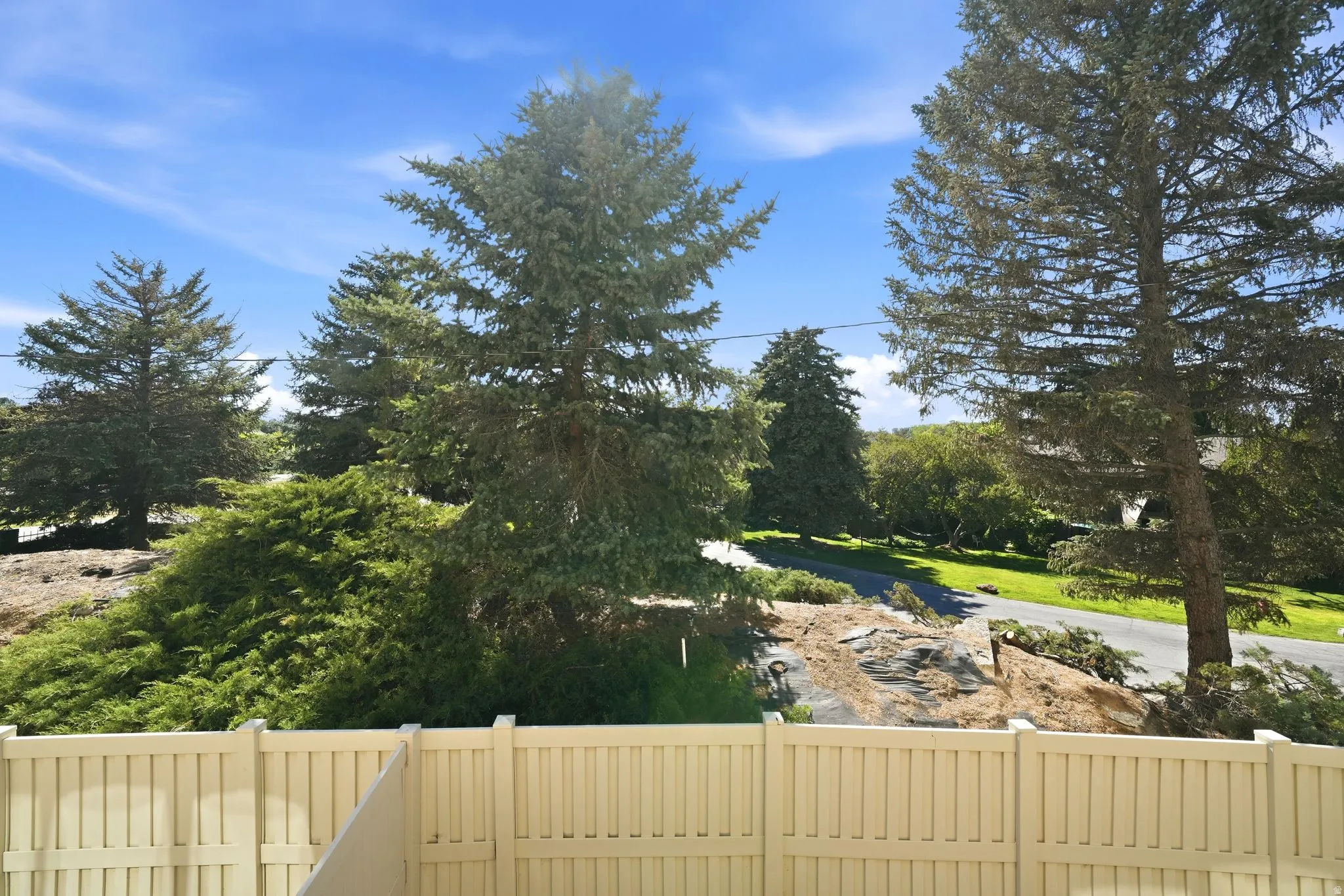 Outdoor space featuring a light-colored privacy fence