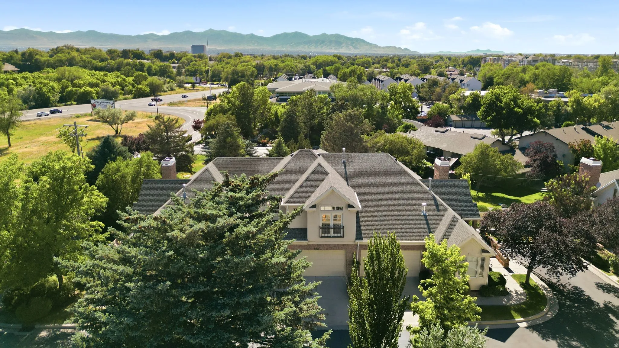 Traditional-style residence featuring a multi-gabled roofline, light-colored exterior siding, and multiple chimneys
