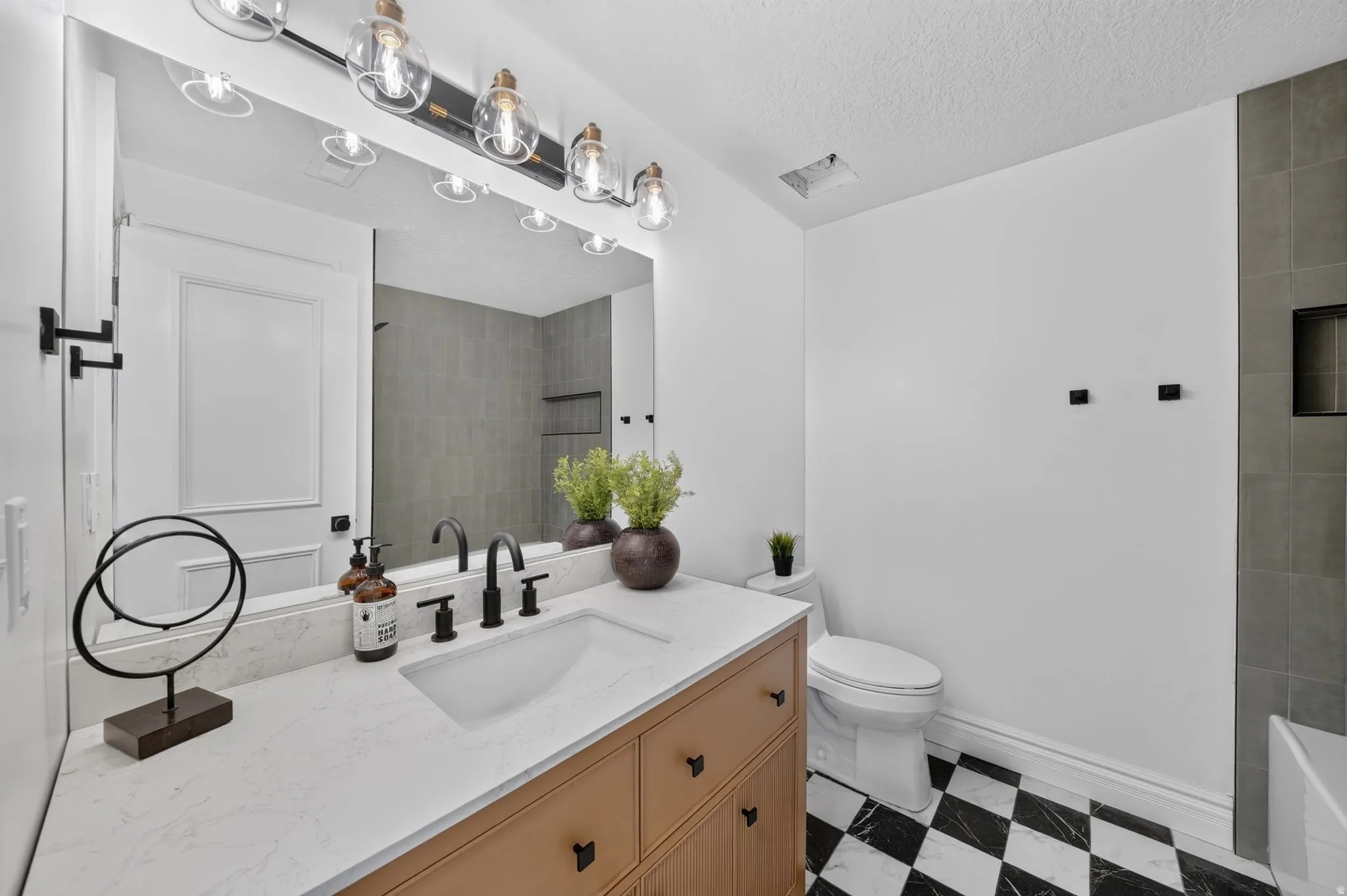 Bathroom featuring a light wood-finish vanity with a white countertop and integrated sink