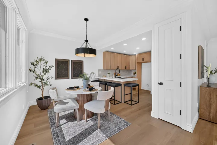 Open concept dining area featuring wood-finish flooring, a contemporary chandelier, and extensive windows